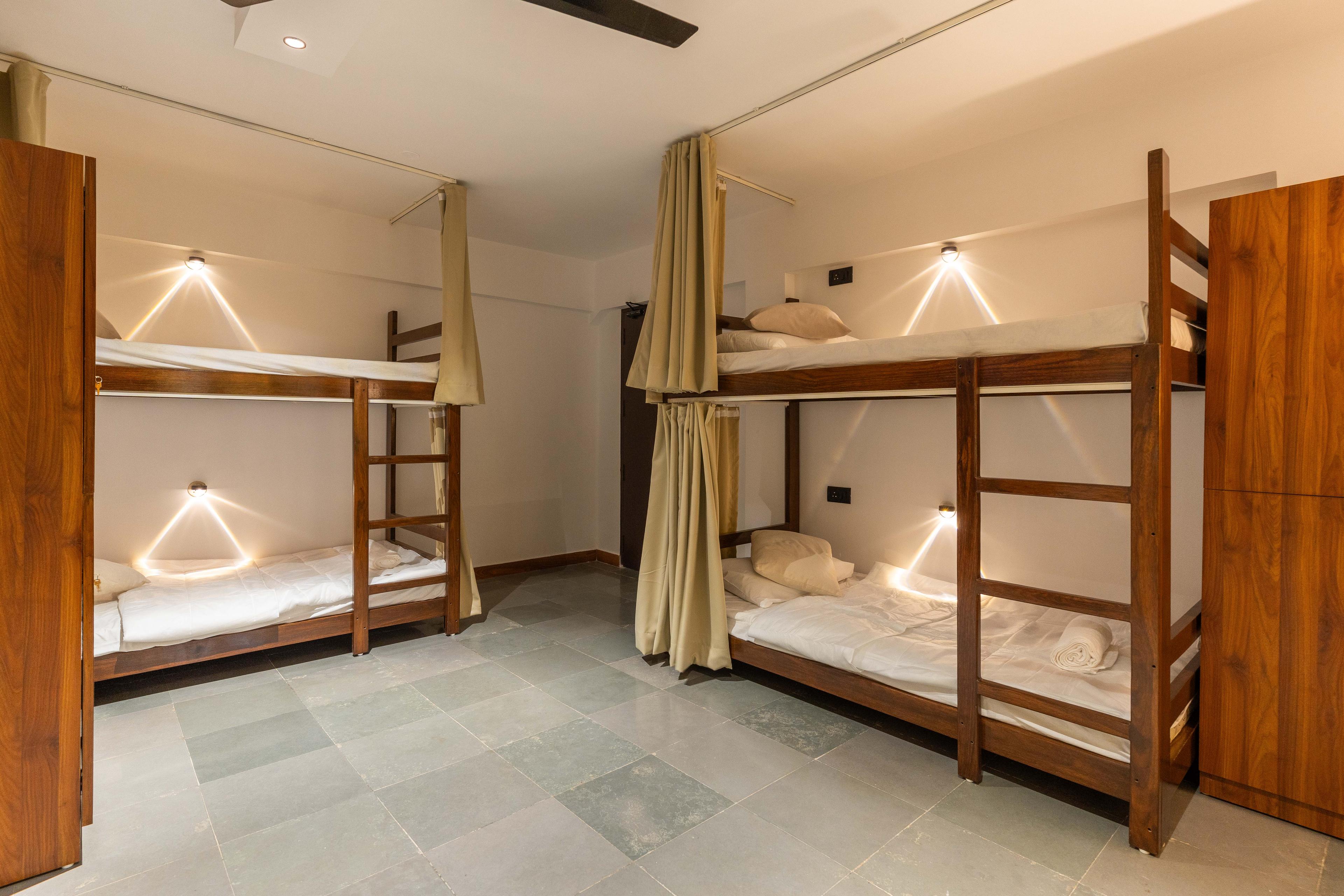 Modern shared hostel room with bunk beds and privacy curtains