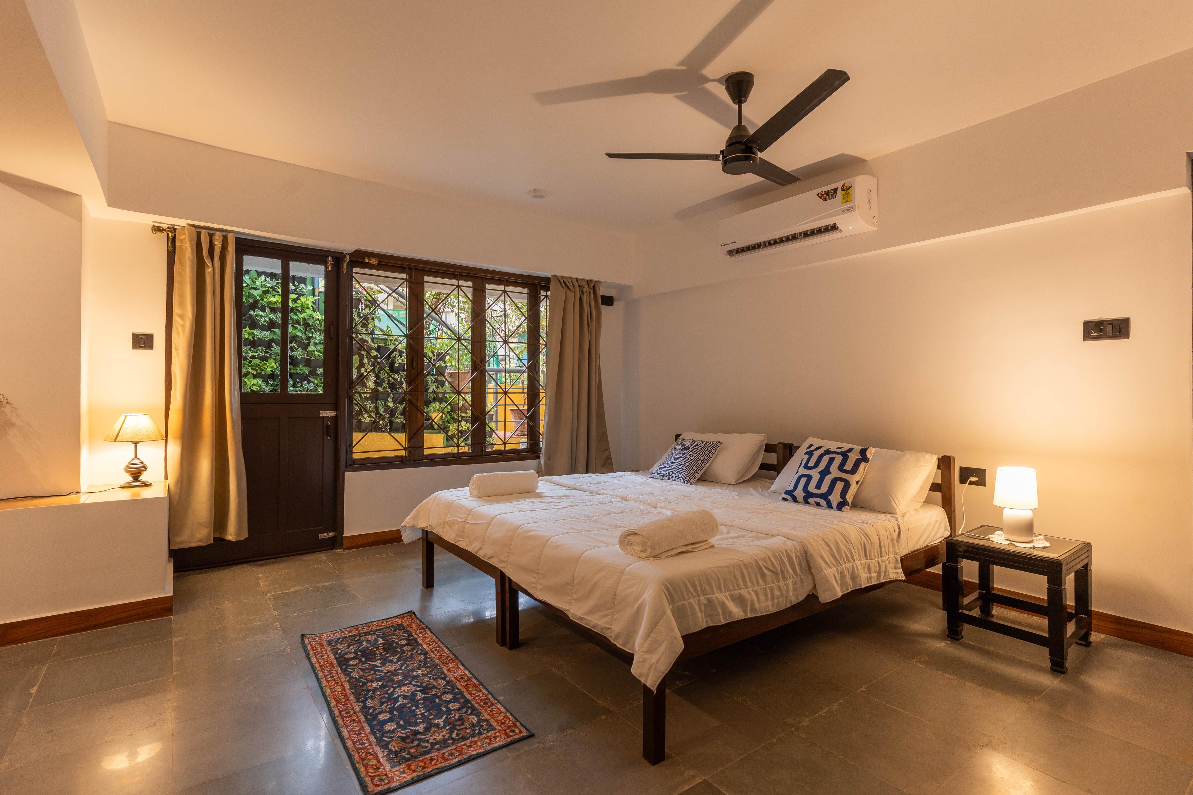Spacious private bedroom with air conditioning, and large windows